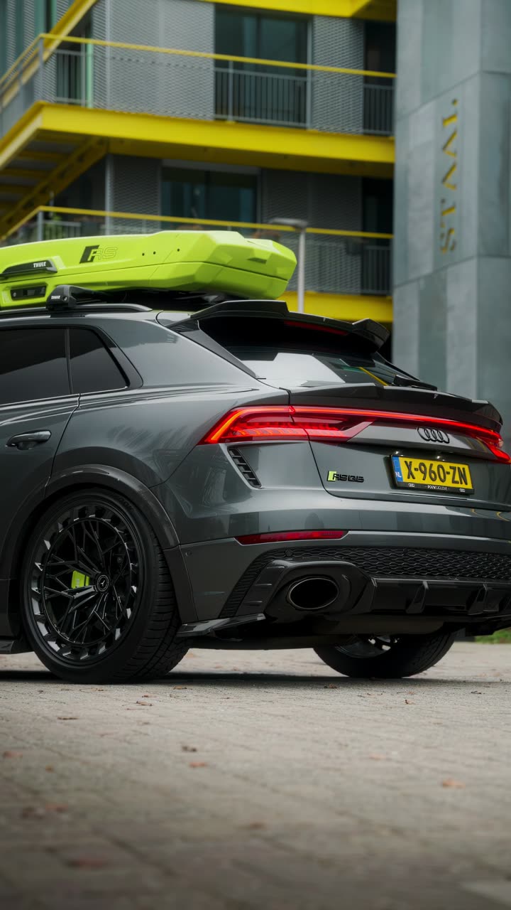 Grijze Audi RS Q8 met een gele dakkoffer
