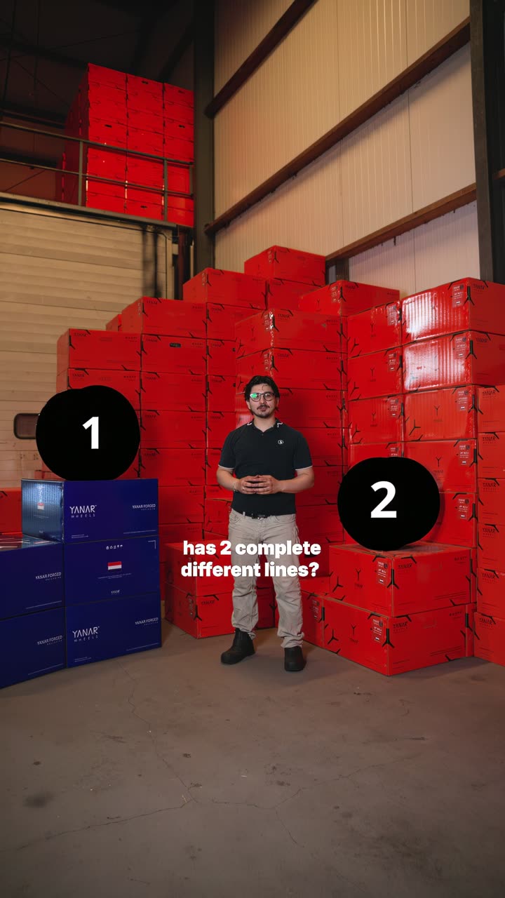 Medewerker van Yanar Wheels voor een stapel rode bandendozen